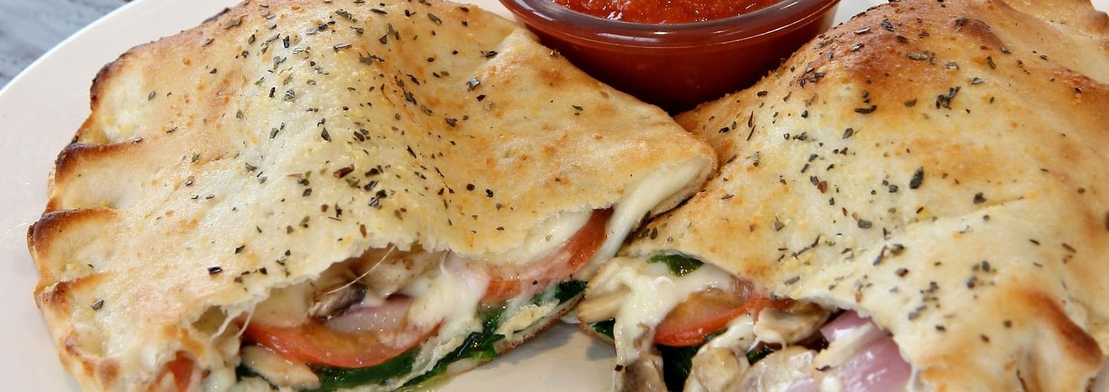 Baked calzone with spinach and tomato